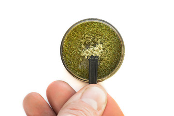 Kief in grinder for weed Trichomes buds of Cannabis And the hands of men macro top view isolated on...