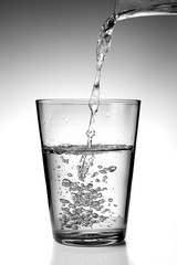 Versando acqua fresca in un bicchiere