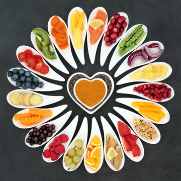 Healthy heart food with fish, fruit and vegetables on slate background. Super food concept with foods high in omega 3 fatty acids, antioxidants, vitamins and minerals. Top view.