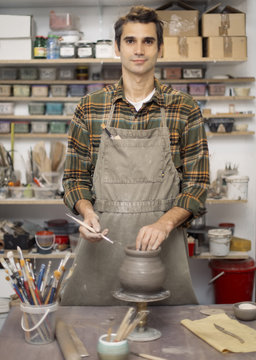 Young man making pottery in workshop