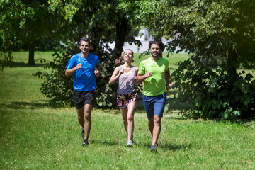 Obraz premium Woman and two young men running in the park