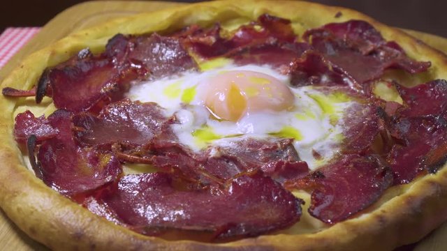 Turkish and Arabic Traditional Ramadan Food Pide or Pizza ingredients with Pastirma which is halal bacon, egg, mozzarella cheese, butter and spice on rustic white wood background. Rotating shot.