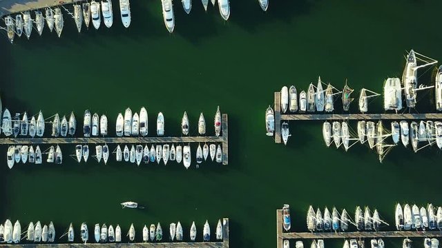 4K Compilation Video. Flight over marina with moored yachts, ships and lighthouse, aerial bird's eye view at sunset.