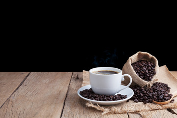 coffee cup and coffee beans on old wood plank background.