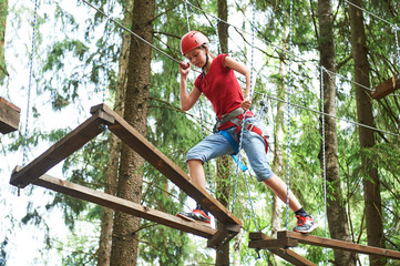 Girl at climbing activity in high wire forest park