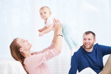 Fototapeta premium Parenting family. Mother and father playing with little newborn baby