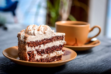 sweet cake with cup of tea on wooden table