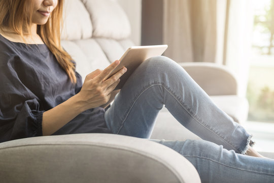 Young woman using tablet on sofa at home