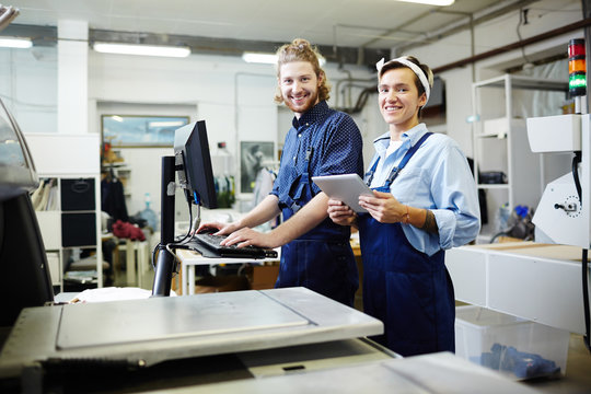 Young staff of graphic printing office looking at camera during work