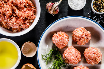 Raw meatballs on wooden background