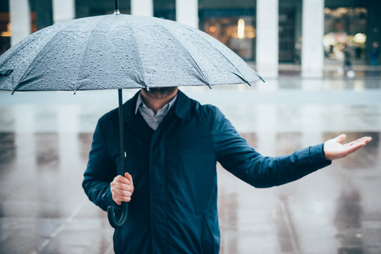 Man Walking In The City With Umbrella On Rainy Day