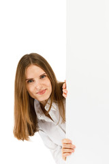 Young attractive girl peeking behind blank board on white background