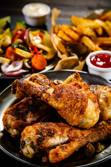 Grilled chicken drumsticks with French fries and vegetables