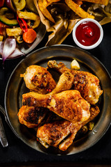 Grilled chicken drumsticks with French fries and vegetables