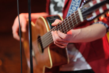 Obraz premium Six string acoustic giant guitar in the hands of a musician