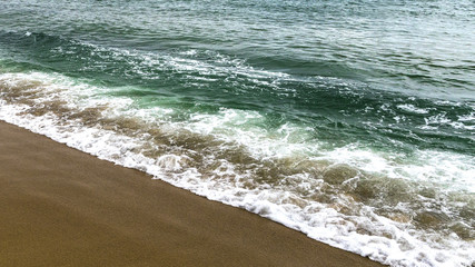 emerald color sea waves on sandy seashore (photo format 16:9)