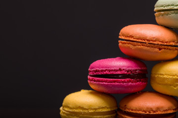 Closeup of colorful macarons on black background