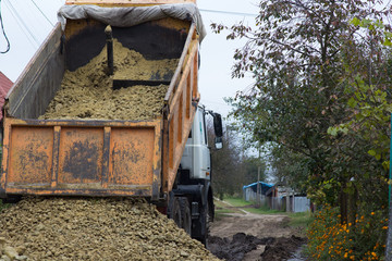 a truck empties gravel