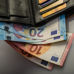 paper euro notes in a wallet and credit cards.