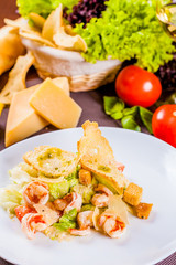 Caesar salad with shrimps on white plate