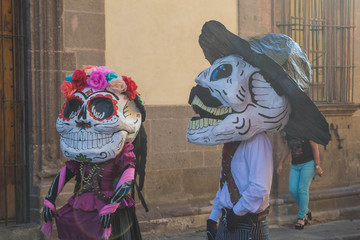 Two people in celebratory costumes and masks for the Day of the Dead festivities, in San Miguel de Allende, Mexico