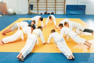Photo sur Plexiglas Arts martiaux Boys in kimono makes push up exercise, kid judo