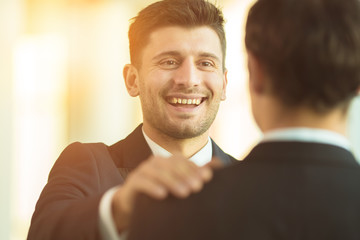 The smile businessmen hold on the shoulder in the office