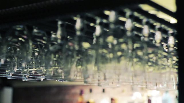 Cocktail glasses hanging over a bar at a nightclub 