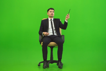 The businessman sit of the chair and gesture on the green background