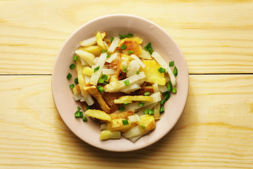 Potatoes slices in a plate on a wood background