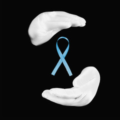 The concept of health protection, prostate cancer, hands with white medical gloves and blue ribbon