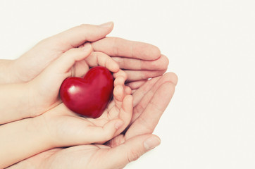 Parent and child holding heart in hand
