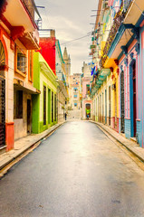 A long narrow, empty street in an old city with colorful houses