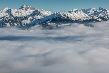 Obraz premium Snow on the top of the mountains and fog down the valley