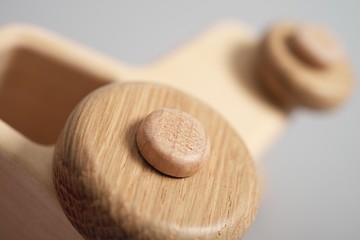 Wooden toy tractor on light isolated background