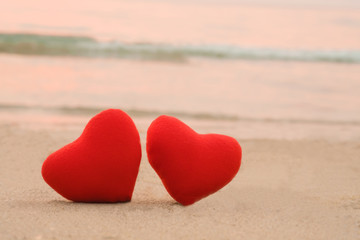 Red heart on the beach in sunset