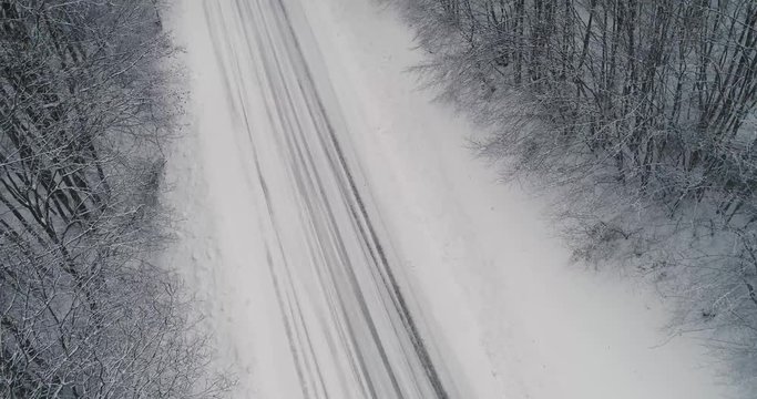 Aerial view of snowy forest with a road