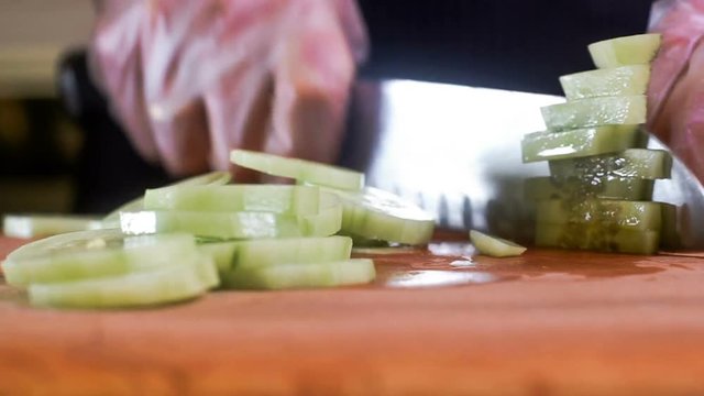 The chef in black apron cuts vegetables. tartar