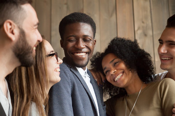 Happy diverse black and white people group with smiling faces bonding together, cheerful african and caucasian young multi ethnic friends having fun laughing embracing, multiracial friendship concept - obrazy, fototapety, plakaty