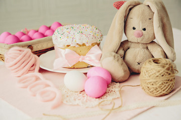 Fototapeta na wymiar Easter cake and pink eggs on a wooden table