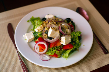 Greek salad on a wooden background . Greek salad on a plate top view . healthy food
