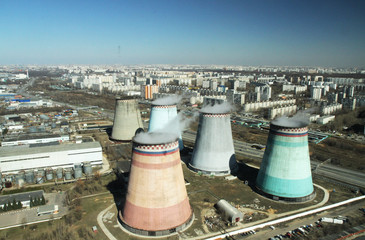 Cooling pipes are several nearby in the city. Photo of a cooling tower in a megacity with a...