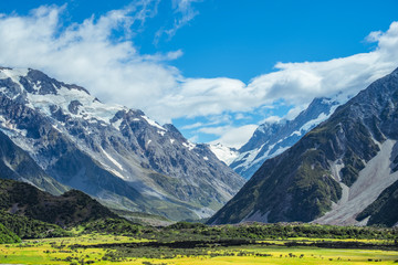 Beautiful scene of road to Mt Cook National park with yellow field, mountain with blue sky and clouds.