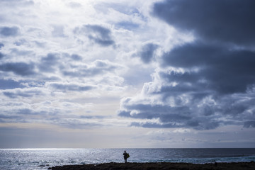 lonely surfer looking at the ocean waiting waves