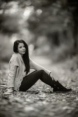 Vintage Heavy Film Grained Photograph of a Beautiful Young Woman Sitting down, Using exreme Shallow...