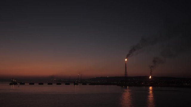 Petrochemical refinery on sea shore in sunrise