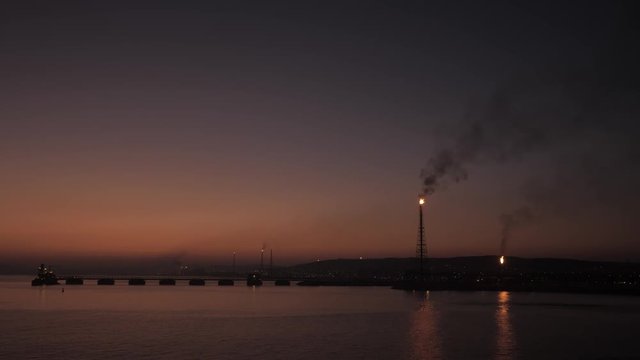 Flare stack of petrochemical refinery in sunrise