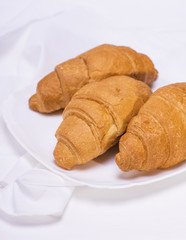 three baked croissants on a white plate