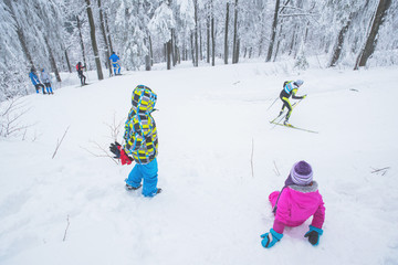 Young fans on professional nordic ski race in white nature