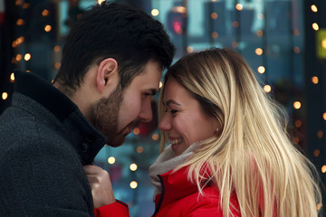 Young couple in love outdoor.Stunning sensual outdoor portrait of young stylish fashion couple. Young beautiful couple kissing on bright blurry background